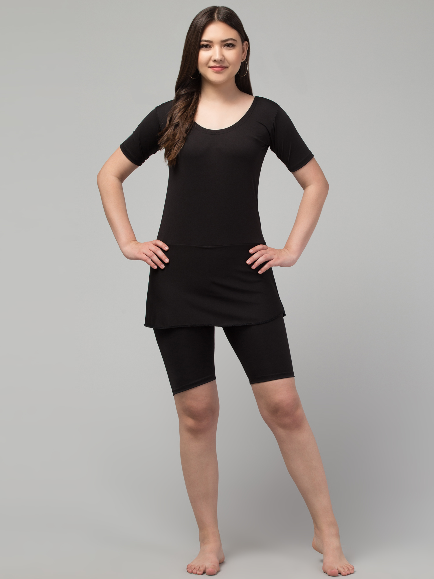 Black solid swimming dress, has a round neck, short sleeves, and attached shorts